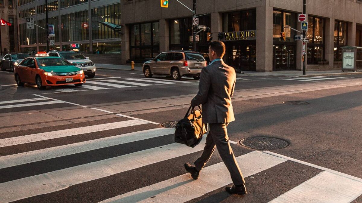 A businessman with a bag crossing the street