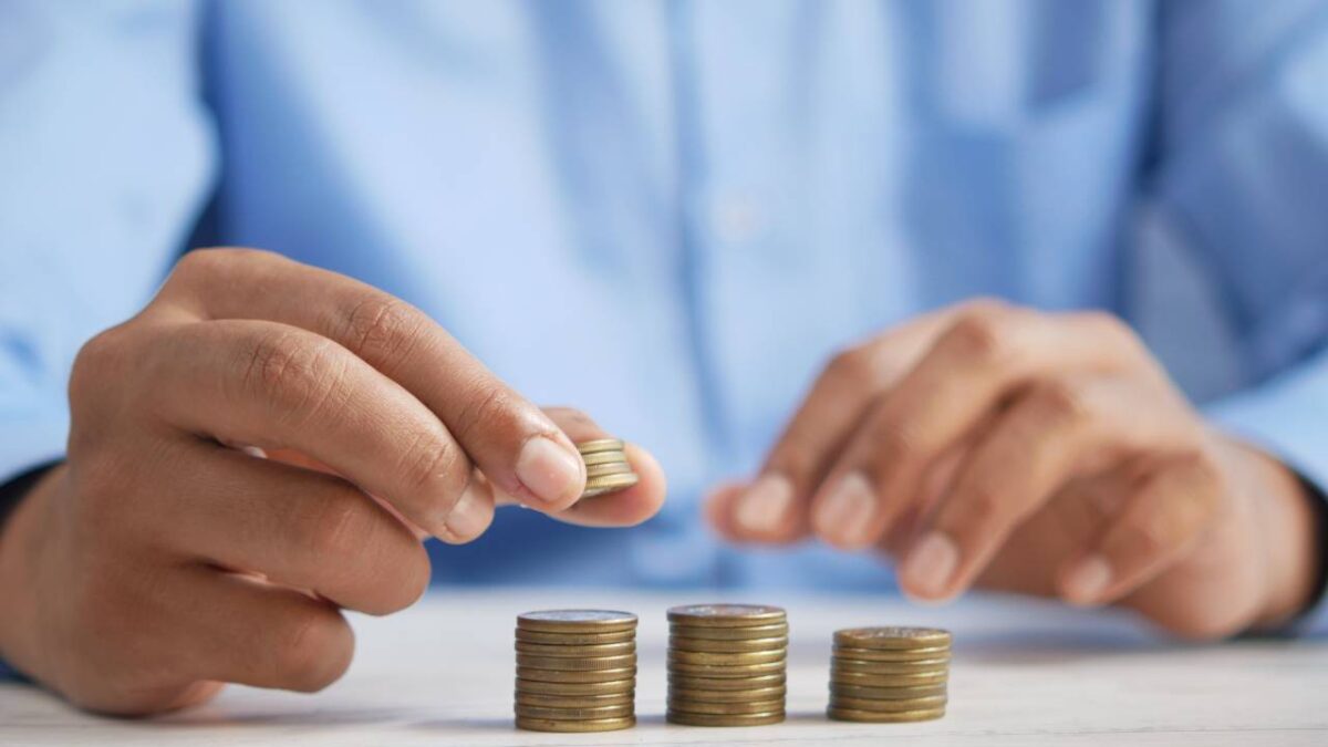 A man wearing a blue shirt stacks coins