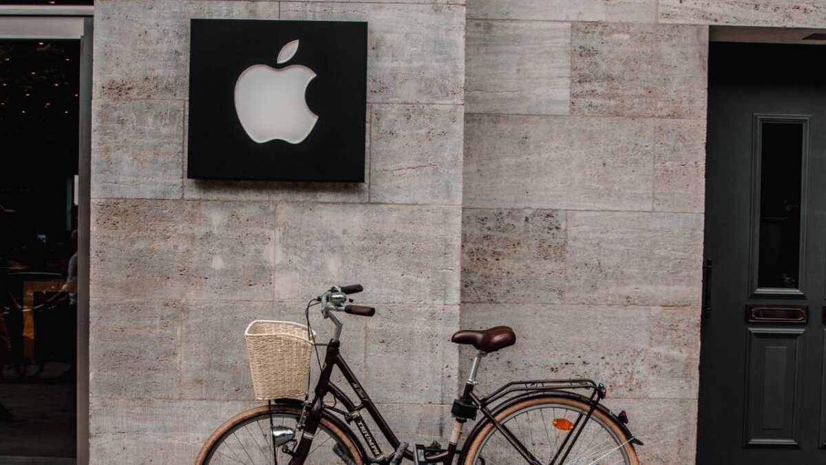 An old bicycle and the Apple logo on the wall