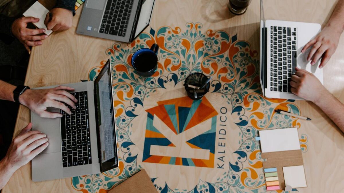 People working on laptops placed on a colourful table