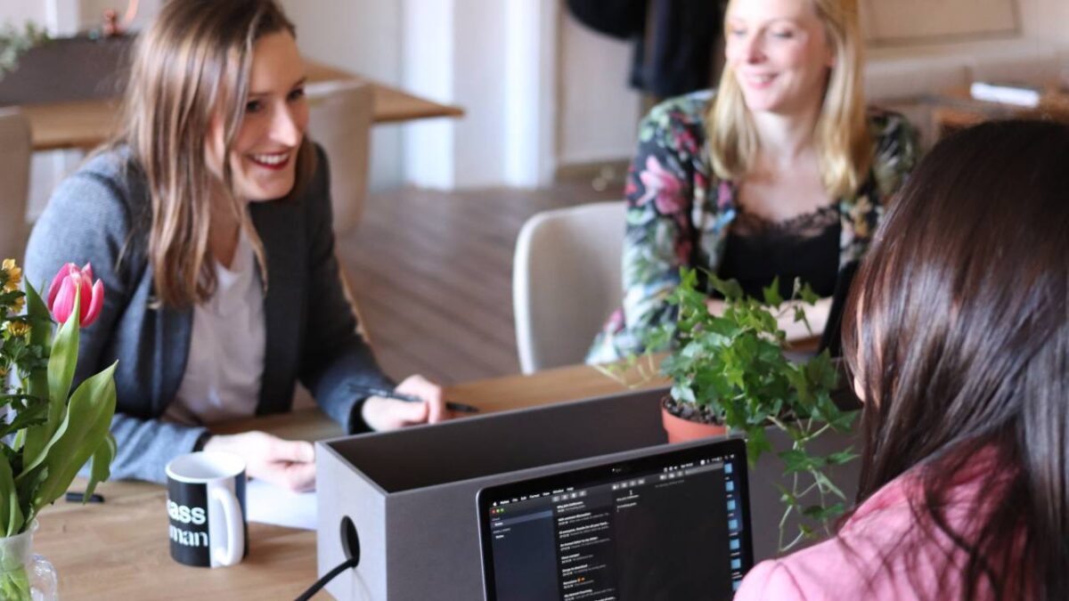 Three female employees laughing together in an innovative work environment