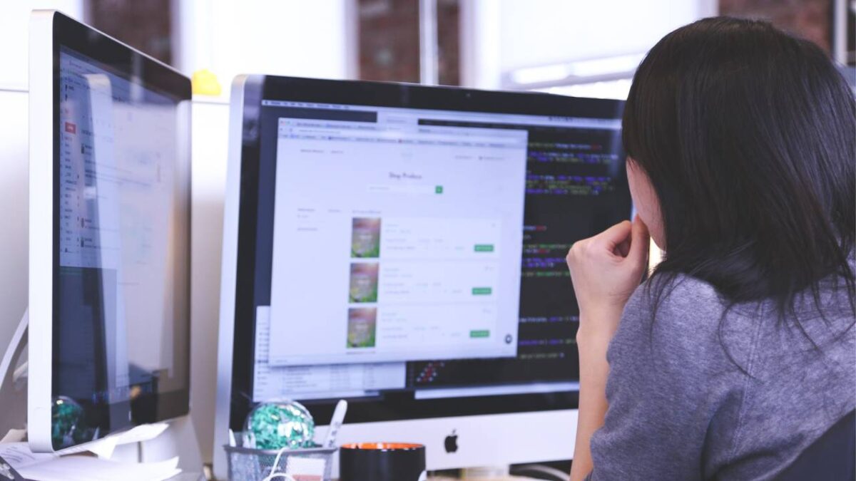 Female web designer working on a two-monitor setup 