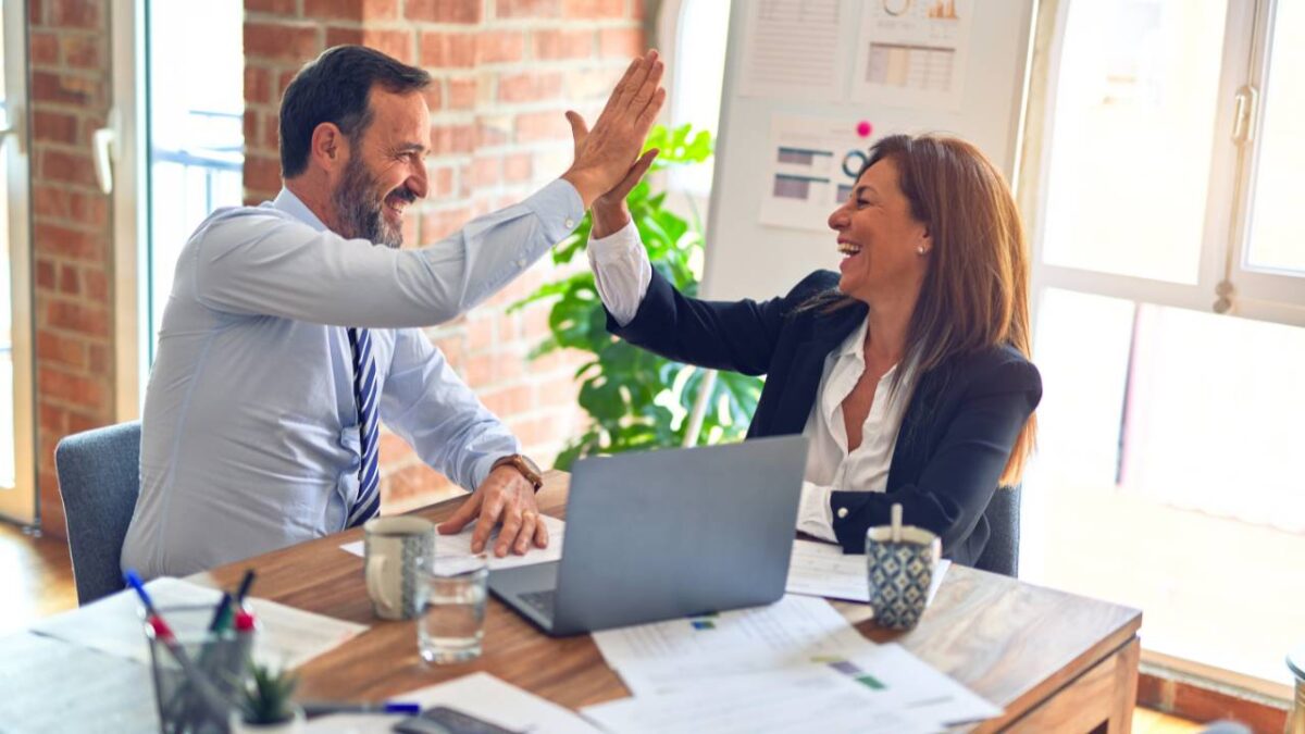 A client and her financial advisor doing a high-five 