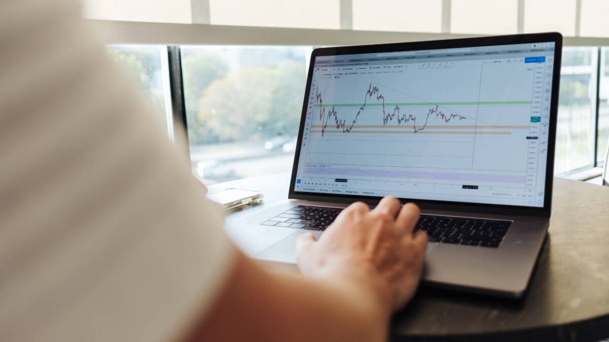 A man looking at a financial graph on his laptop