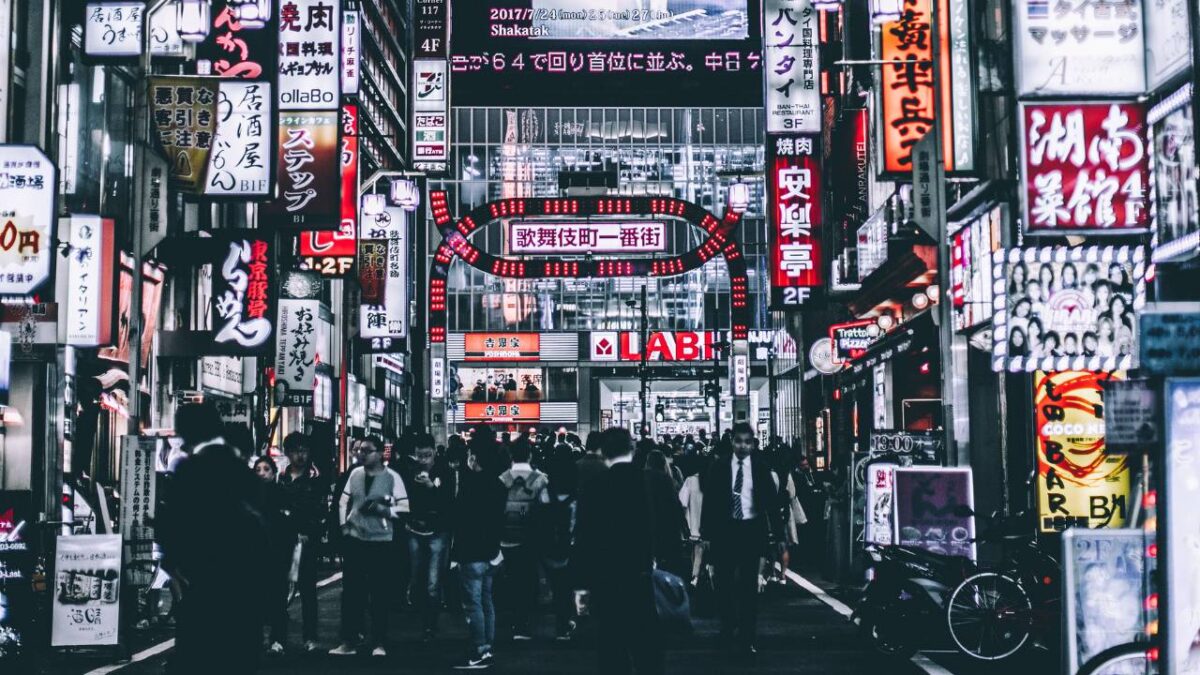 An Asian street full of people and neon signage