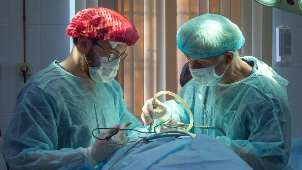 Two medical professionals conducting an operation on a patient 