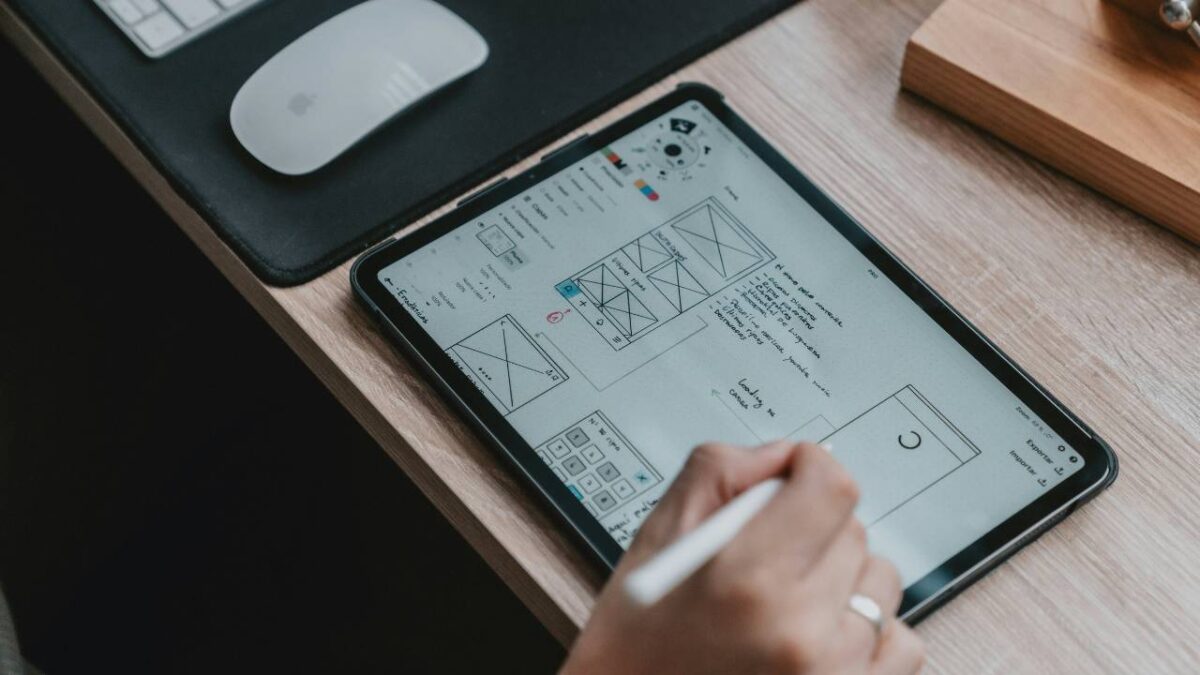 A photo of a woman working on an UX design project on her tablet