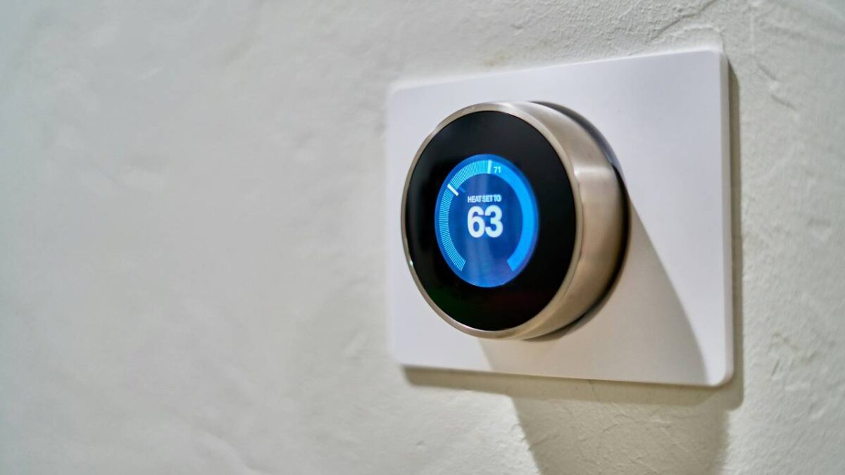 A smart heat-regulation device mounted on a white wall